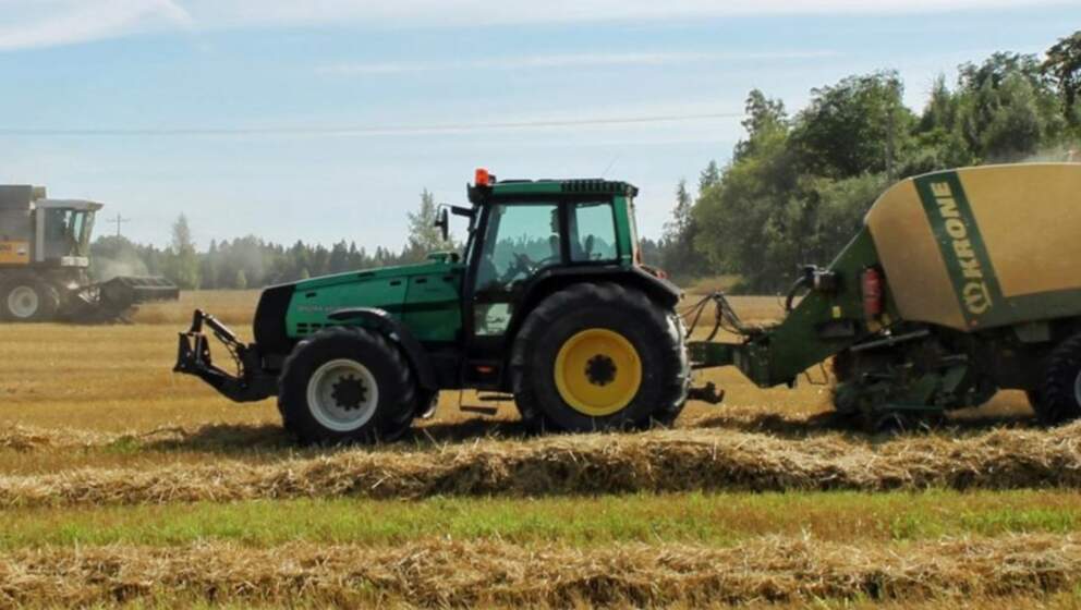Grön traktor på fältet använder motorolja