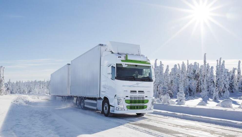 En vit lastbil i ett vinterlandskap